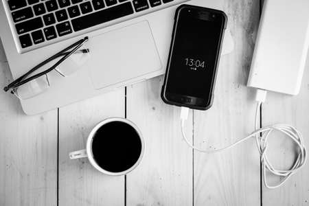 Wooden desk with various gadgets and accessories, top viewの写真素材