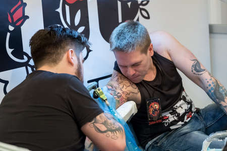 Moscow, Russia - April 2, 2017: Artist making a tattoo for Tattoofest visitorのeditorial素材