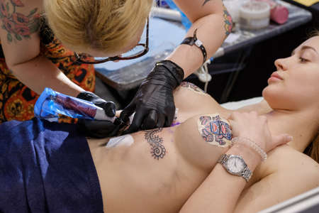 Moscow, Russia - April 2, 2017: Artist making a tattoo for Tattoofest visitorのeditorial素材