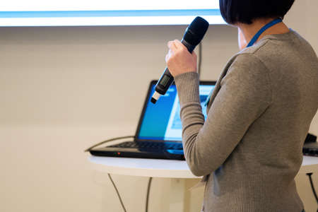 Businesswoman talking at conference holding a microphoneの写真素材
