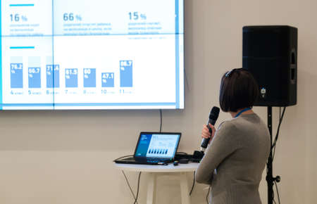 Businesswoman talking at conference holding a microphoneの写真素材