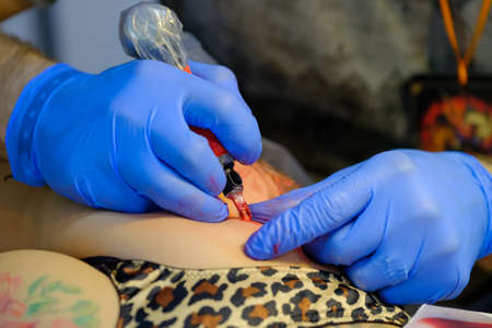 Moscow, Russia - April 2, 2017: Artist making a tattoo for Tattoofest visitorのeditorial素材