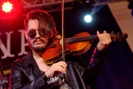 Moscow, Russia - April 2, 2017: Young man playing the violin at Tattoofest