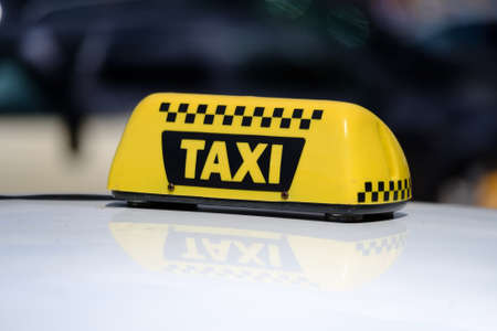 Taxi sign on the roof of a carの写真素材