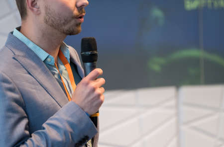 Speaker at conference holding microphone in the handの写真素材