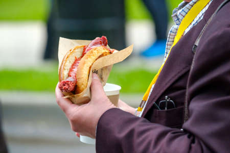 Man holds hotdog in the handの写真素材