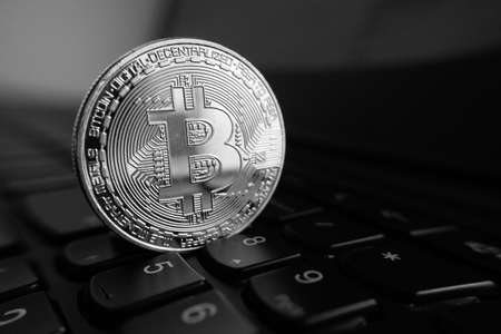 Silver bitcoin coin on the black laptop keyboard. Cryptocurrency conceptの写真素材