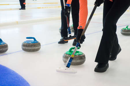 Team members play in curling at championshipの写真素材