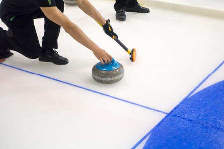 Team members play in curling at championshipの写真素材