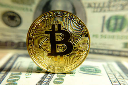Golden bitcoin coin on the one hundred dollars banknote. Macro. Cryptocurrency concept