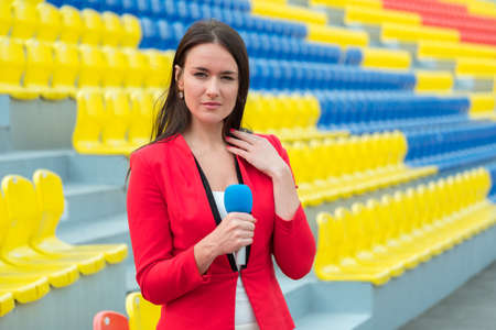Young girl TV reporter is broadcasting from stadium