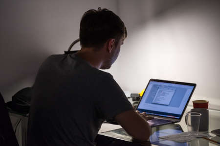 Man works at laptop, back viewの写真素材