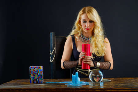 Woman fortune teller with crystal ball portrait on black