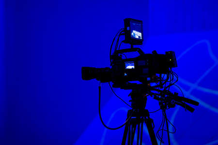 Professional tv camera silhouette on blue backgroundの写真素材