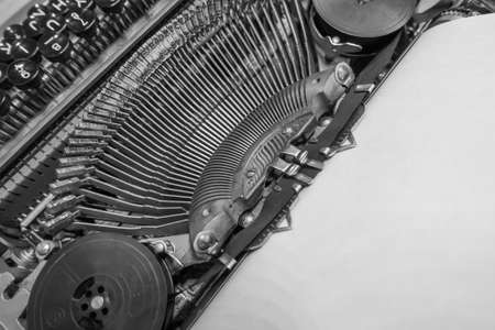 Typewriter ready for use with blank paper installed macro black and white background