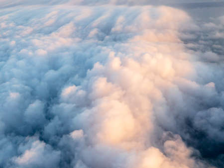 Top aerial view of fluffy clouds flying on the plane
