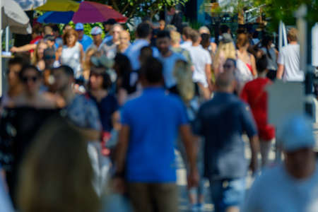 Unidentified crowd of people walking on the street at sunny day time