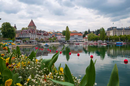 View to Montreux city from Geneva lake embankment at sunny summer day, flowers at foreground.