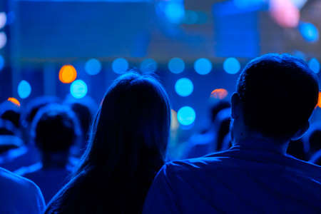 Audience listens to the lecturer at the business conference, back view