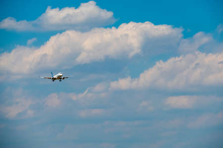 Passenger airplane flying in the cloudy skyの写真素材