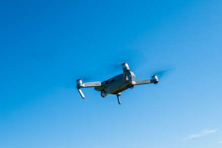 Folding drone flying in a blue sky