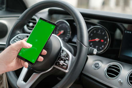 Man using smartphone on the background of luxury class car dashboard