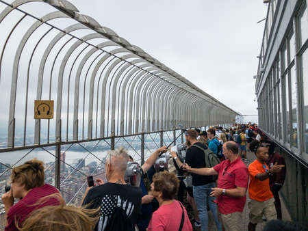 New York, USA - September 6, 2018: Tourists look at Manhattan sights from the roof observing deck of the Empire State Buildingのeditorial素材