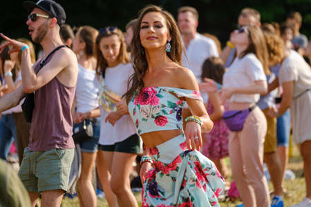 Moscow - June 22, 2019: Young woman dancing at open air music festival, spectators at background