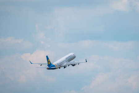 Zurich, Switzerland - July 19, 2018: Ukraine airlines airplane flying in cloudy sky, rear view