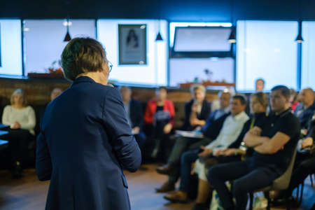 Female presenter speaks to audiences at conferenceの写真素材
