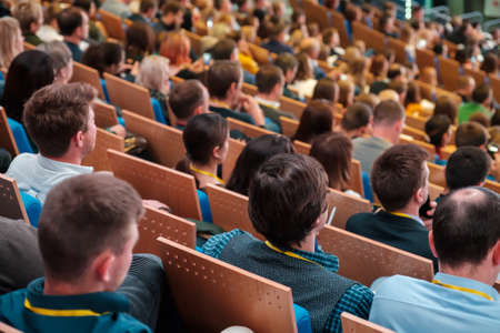 Business conference attendees sit and listen to lecturer, rear top viewの写真素材