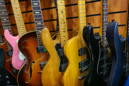 Different electric guitars hang in the music instruments storeの写真素材