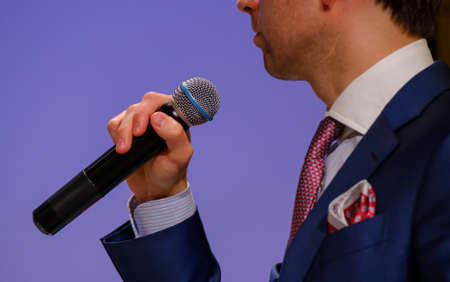 Man speaks, holding a microphone in his handの写真素材