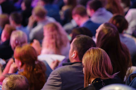 Business conference attendees sit and listen to lecturer, rear viewの写真素材