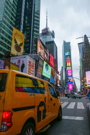 New York, USA - September 6, 2018: Time Square dusk time cityscape, yellow taxi at foreground