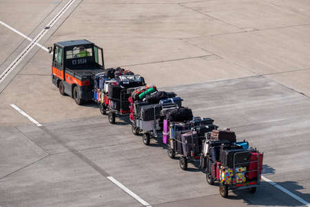 Zurich, Switzerland - July 19, 2018: Loader carries passengers luggage at the airportのeditorial素材