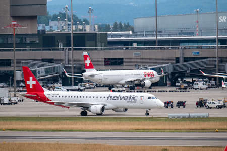 Zurich, Switzerland - July 19, 2018: Swiss and Helvetic airlines airplanes preparing for take-off at...