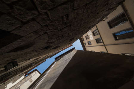 Narrow street view from the bottom up to the sky in old cityの写真素材
