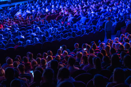 Business conference attendees sit and listen to lecturer, rear viewの写真素材