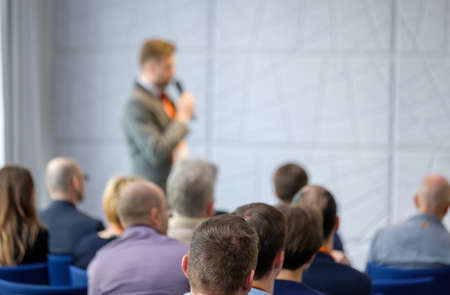 Audience listens lecturer at workshop in conference hall