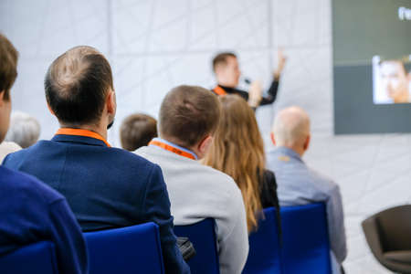 Audience listens lecturer at workshop in conference hall