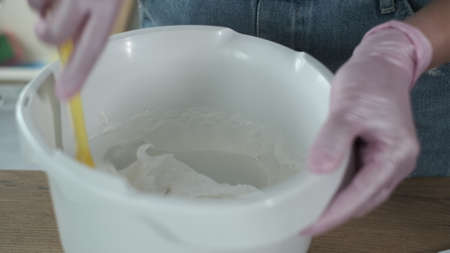 From above anonymous female adding powdered sugar into bowl then mixing meringue during dessert...