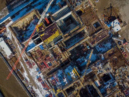 Top view of industrial machinery and building under construction located in enclosure in snowy outskirtsの写真素材