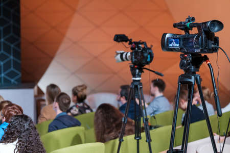 Professional cameras near audience during business seminarの写真素材