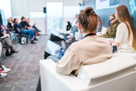 Unrecognizable man listening to speaker during business seminar