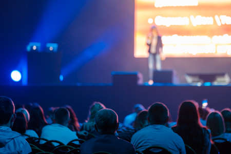 Audience listening to speaker in neon light