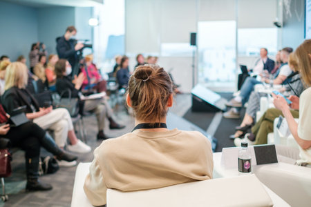 Unrecognizable man listening to speaker during business seminarの写真素材