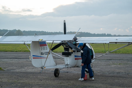 Male mechanic checking light plane on aerodromeのeditorial素材