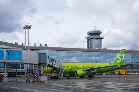 Airplane outside contemporary airport buildingのeditorial素材