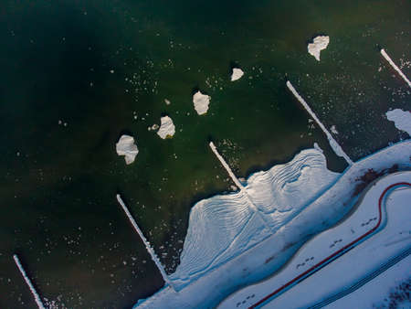 Frozen snowy seacoast with ice floating on seawaterの写真素材